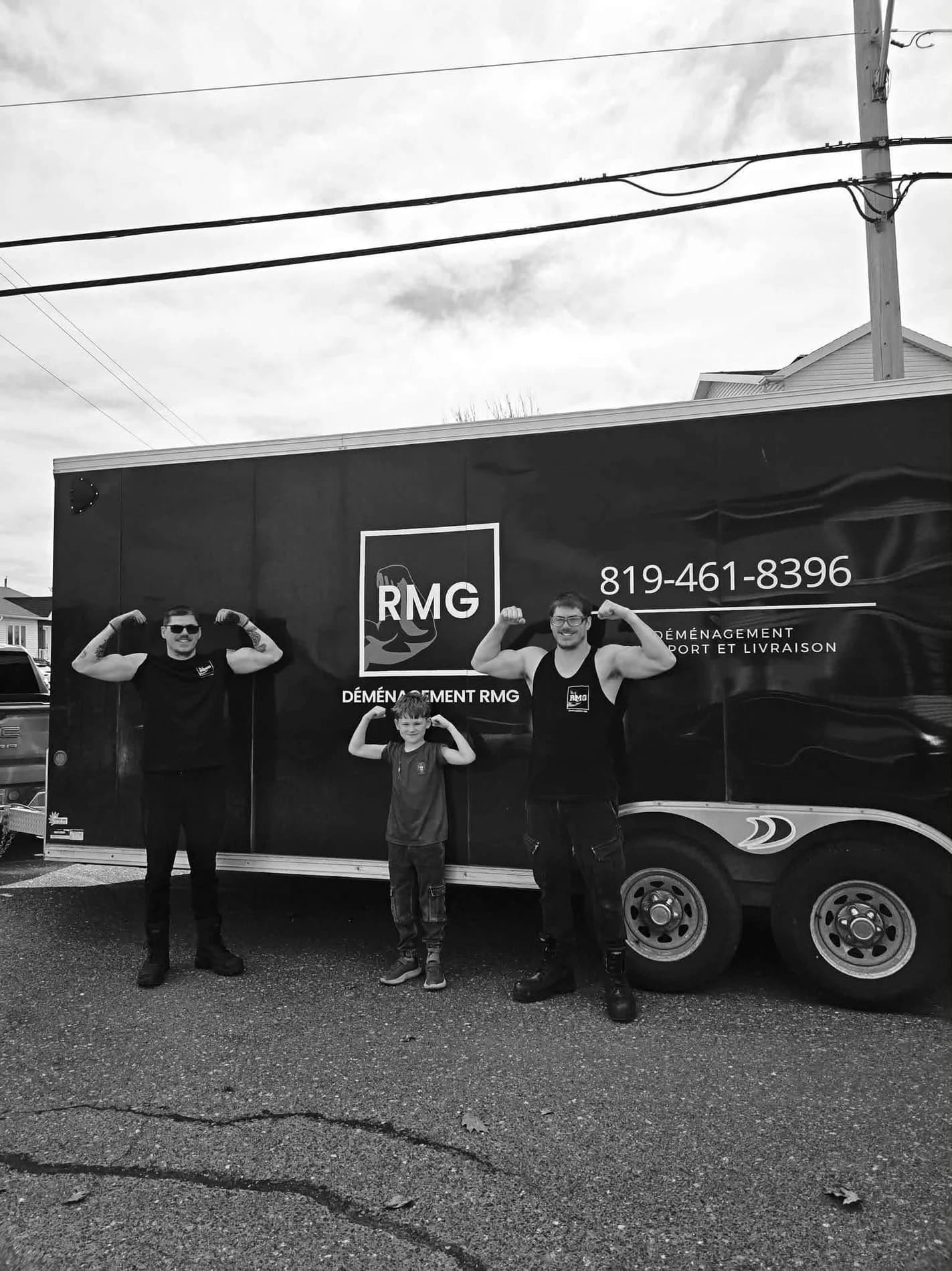 RMG crew in front of their black moving trailer